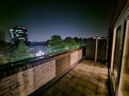 uma varanda com vista para a cidade à noite em Stunning 1-Bed Apartment in London em Londres