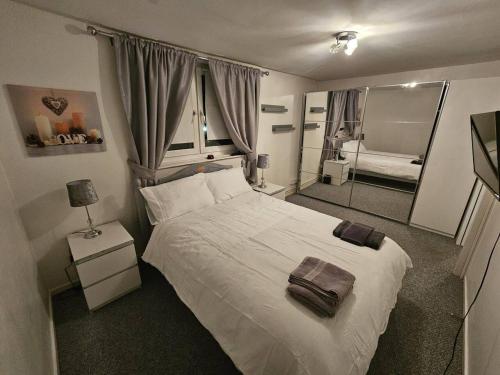 um quarto com uma grande cama branca e um espelho em Stunning 1-Bed Apartment in London em Londres