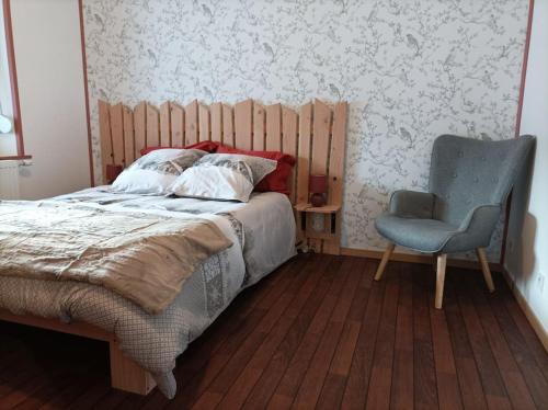 1 dormitorio con 1 cama y 1 silla en Marguerite, en Bussang