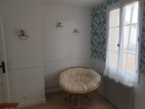 een witte kamer met een ronde stoel en een raam bij Une halte au beau Millet in Coutras