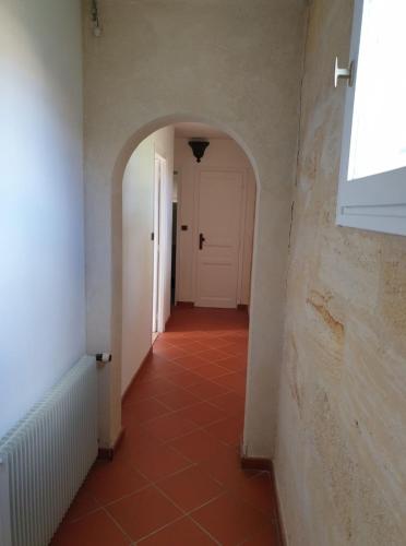 - un couloir avec une porte blanche et du carrelage rouge dans l'établissement Une halte au beau Millet, à Coutras