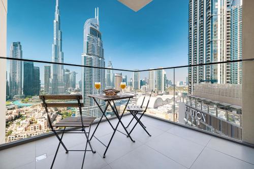 a balcony with a table and chairs and a view of the city at SmartStay at Burj Royale - Full Burj Khalifa View - Brand New Luxury Apartments in Dubai