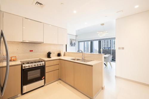 a kitchen with a sink and a stove top oven at SmartStay at Burj Royale - Full Burj Khalifa View - Brand New Luxury Apartments in Dubai