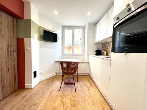 a small kitchen with a table and a window at La Loge Parisienne, 300m gare, Climatisation, Téléphérique in Grenoble