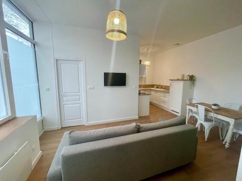 a living room with a couch and a table at Reyloft • Situé au cœur de Douai & Wifi fibre in Douai