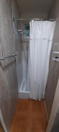 y baño con ducha con cortina blanca. en Cabaña 3 personas Villarrica Pucón en Pucón