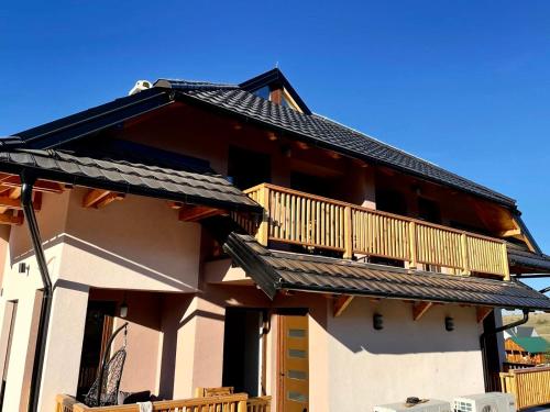 a building with a balcony on top of it at Golden Gondola Tornik in Zlatibor