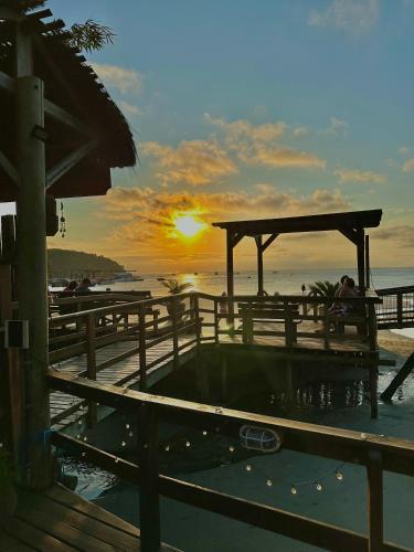 a hot tub on the beach with the sunset in the background at Pousada & Camping Tubarão in Ilha do Mel