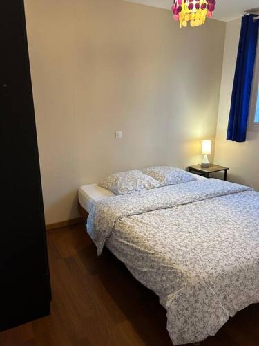 een slaapkamer met een bed met een wit dekbed bij Maison conviviale in Villejuif