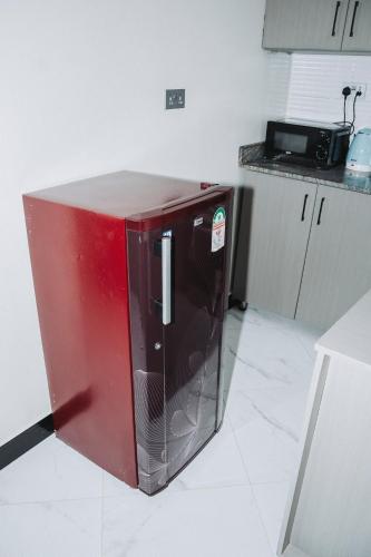 a red refrigerator sitting in the middle of a kitchen at Cozy Residence I, 1 bedroom Apartment Kyanja in Kampala
