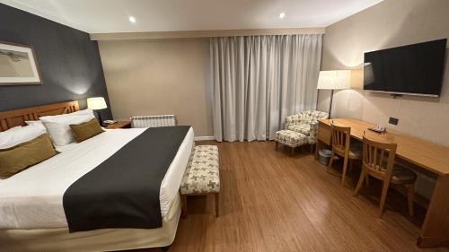 een hotelkamer met een bed en een bureau bij Hotel Canal Beagle in Ushuaia