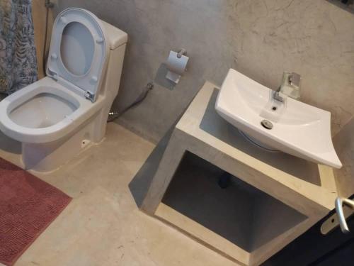 a bathroom with a white toilet and a sink at Villa Fayenne in Sali Tapé