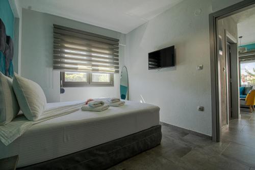 a bedroom with a bed with towels on it at STREET 90 Luxury Apartment in Keramoti