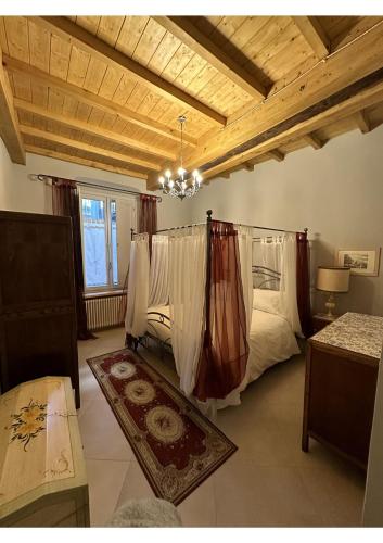 una camera da letto con un letto con tende e un tappeto di Appartamenti La Vecchia Latteria a Ceva