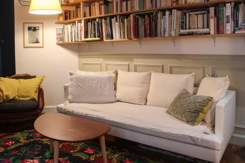 a couch in a living room with a book shelf at Charming 49 m love cocoon in Paris 12th in Paris