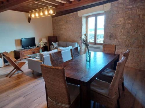 a living room with a wooden table and chairs at Les Hauts de Cordes in Cordes-sur-Ciel