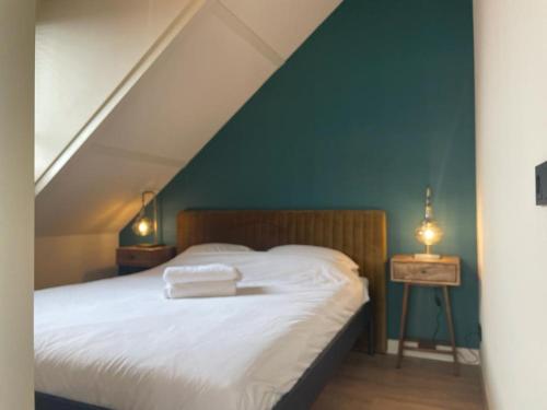 um quarto com uma cama com uma parede azul em De Nieuwe Poort Kortgene em Kortgene