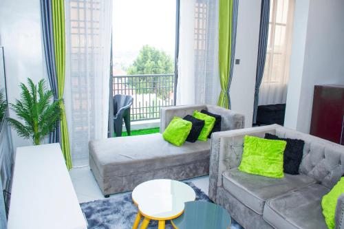 a living room with two couches and a balcony at Cozy Residence I, 1 bedroom Apartment Kyanja in Kampala