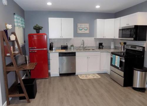 a kitchen with white cabinets and a red refrigerator at Fishing Retreat C in Pensacola