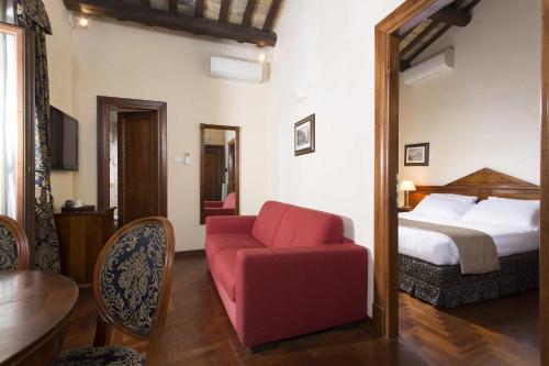 een slaapkamer met een bed en een rode stoel bij Hotel Teatro Pace in Rome