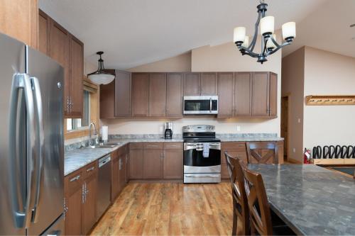a kitchen with wooden cabinets and a stainless steel refrigerator at Mama Bear in Valemount