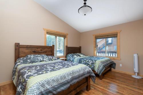 two beds in a room with two windows at Mama Bear in Valemount