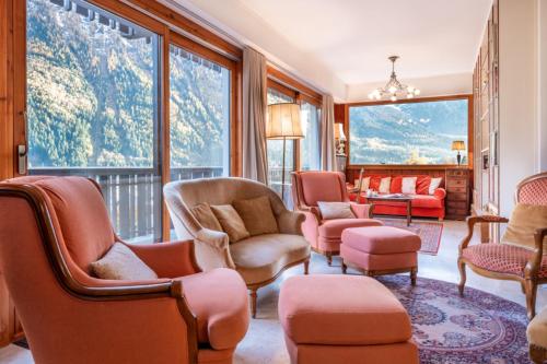 - un salon avec des chaises, des tables et de grandes fenêtres dans l'établissement Spacious apartment with balcony in Chamonix, à Chamonix-Mont-Blanc