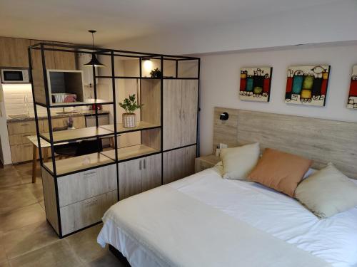 a bedroom with a white bed and a book shelf at La Merced Apart in Córdoba