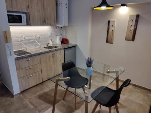 a kitchen with two chairs and a glass table at La Merced Apart in Córdoba