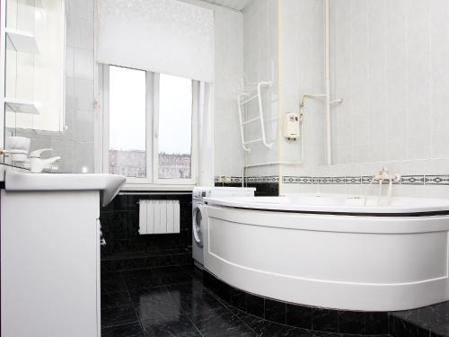 a white bathroom with a tub and a sink at ApartLux na Ploshadi Pobedy in Moscow