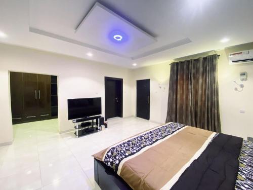 - une chambre avec un lit et une télévision à écran plat dans l'établissement Captivating 5-Bed house pent house in Lekki Lagos, à Lagos