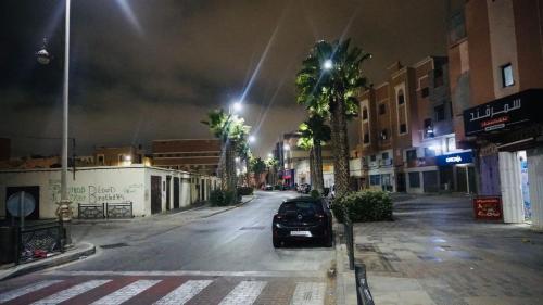 ein Auto, das nachts auf einer Stadtstraße parkt in der Unterkunft العيون شارع 24 نوفمبر قرب قروان in El Aaiún
