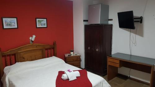 a bedroom with a bed and a desk with a television at Hotel Bella Unión in Bella Unión