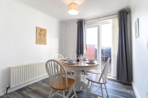 a dining room with a table and chairs and a window at Free Parking 3 Double Bedroom Sunderland House 10 mins drive to Nissan Ideal for Long Term Contractor etc Stays - see our Dwellcome Home Ltd site for assurance in Pallion