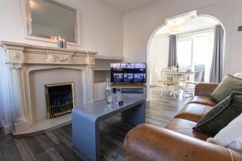 a living room with a fireplace and a couch at Free Parking 3 Double Bedroom Sunderland House 10 mins drive to Nissan Ideal for Long Term Contractor etc Stays - see our Dwellcome Home Ltd site for assurance in Pallion