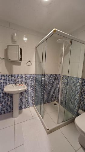 a bathroom with a shower and a sink and a toilet at Apart Angra dos Reis I in Angra dos Reis