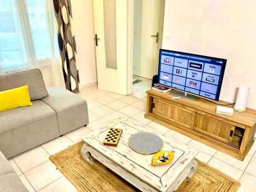 un salon avec un canapé et une télévision dans l'établissement Maison 3 ch. Garage, jardin, 10 min circuit, au Mans