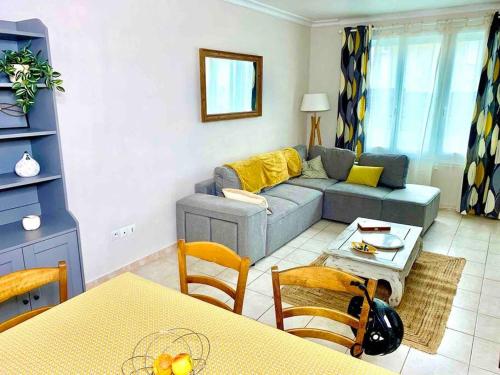 un salon avec un canapé et une table dans l'établissement Maison 3 ch. Garage, jardin, 10 min circuit, au Mans