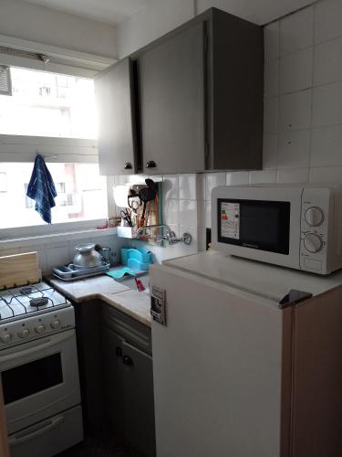 uma cozinha com um frigorífico branco e um micro-ondas em CÓMODO MONOAMBIENTE ZONA ALDREY em Mar del Plata