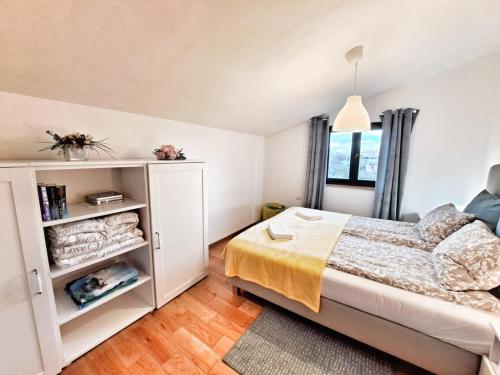 a small bedroom with a bed and a window at Villa Stone Pearl with heated swimming pool in Sveti Filip i Jakov