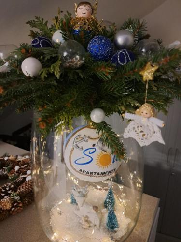 a vase filled with christmas decorations on a table at SOLEK Apartamenty i pokoje gościnne in Mielno