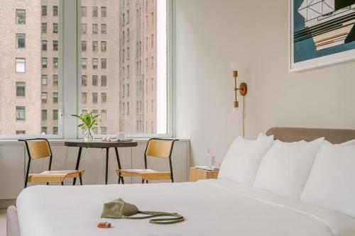 a hotel room with a bed and a table with chairs at Sonder Battery Park in New York