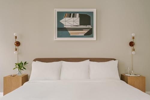 um quarto com uma cama e uma fotografia de um barco em Sonder Battery Park em Nova Iorque