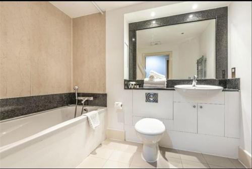 a bathroom with a tub and a sink and a toilet at LondonEYE private bedroom in shared flat in London