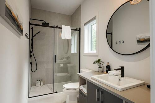 uma casa de banho com um chuveiro, um lavatório e um espelho. em Modern Contemporary Luxury Chalet em La Conception
