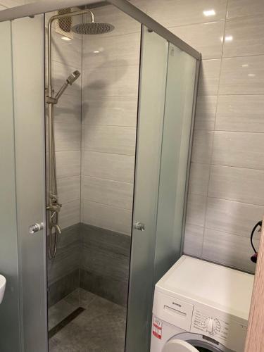 a shower in a bathroom with a washing machine at Apartments Апартамент Рабочая 81, Кирова Kirova in Dnipro