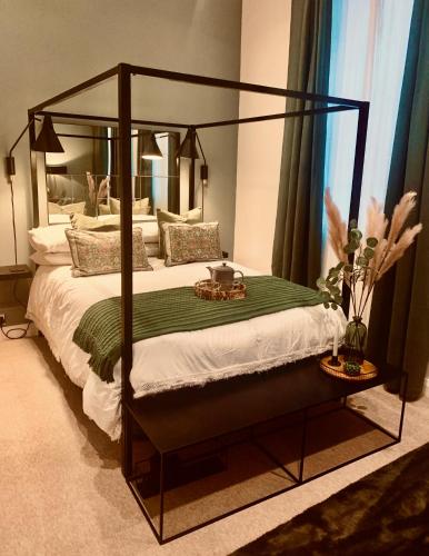 a bedroom with a bed with a black canopy bed frame at The Fifth Quarters, Grade II Listed Apartment, The Lace Market, NG1, City Centre, Nottingham, Sleeps 4 in Nottingham