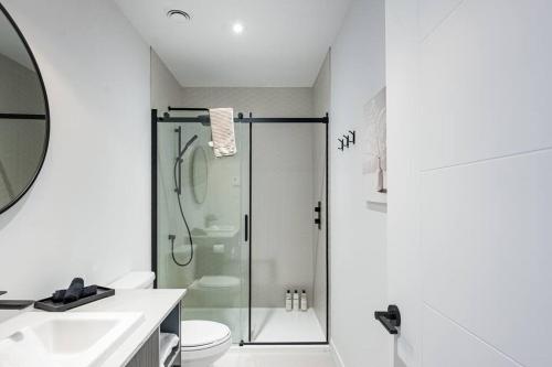 een badkamer met een douche, een toilet en een wastafel bij Modern Luxurious Chalet near Tremblant in La Conception
