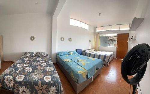 1 dormitorio con 2 camas y ventana en Hotel Pinos del Mar, en Zorritos