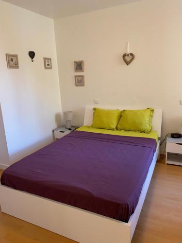 - une chambre dotée d'un grand lit avec des draps violets et jaunes dans l'établissement Centre ville, à Nice